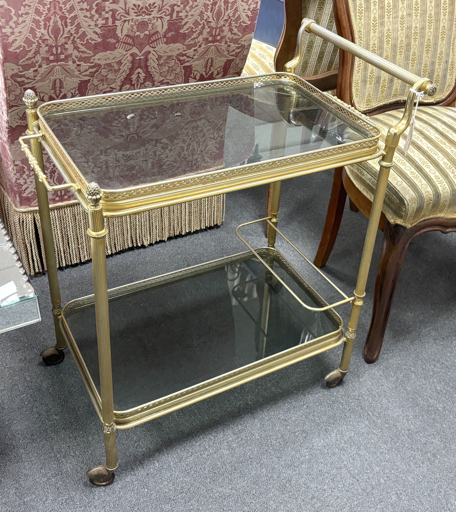 A Maison Jansen style gilt metal and smoked glass two tier trolley, width 64cm, depth 41cm, height 74cm